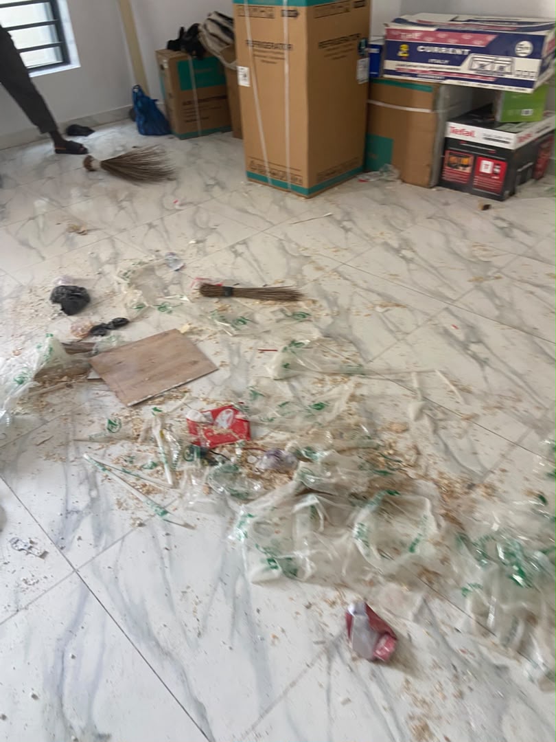 Marble floor covered in construction debris, plastic wrapping and dust before cleaning